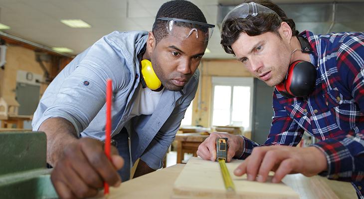 Zwei Männer schauen prüfend auf ein Bauteil