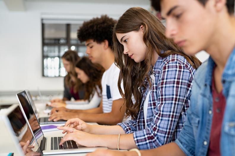 Jugendliche arbeiten nebeneinander an Laptops