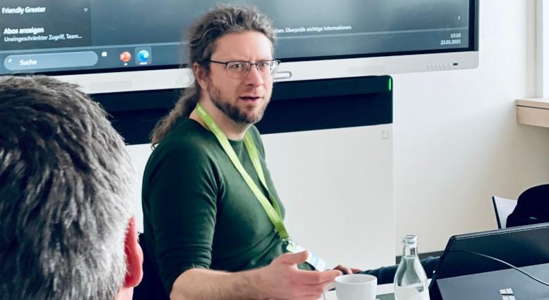 Oliver Nahm in einem Workshop-Raum am Tisch sitzend