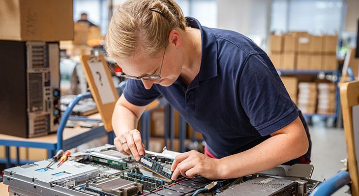 Frau setzt Bauteil in Computer ein