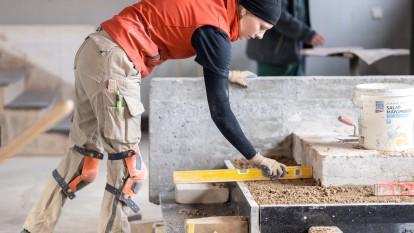 Person mit Wasserwaage auf Baustelle