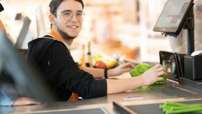 Junger Mann an Supermarkt-Kasse