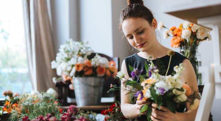 Frau in Blumengeschäft präpariert Blumenstrauß