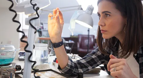 Goldschmiedin inspiziert Edelstein